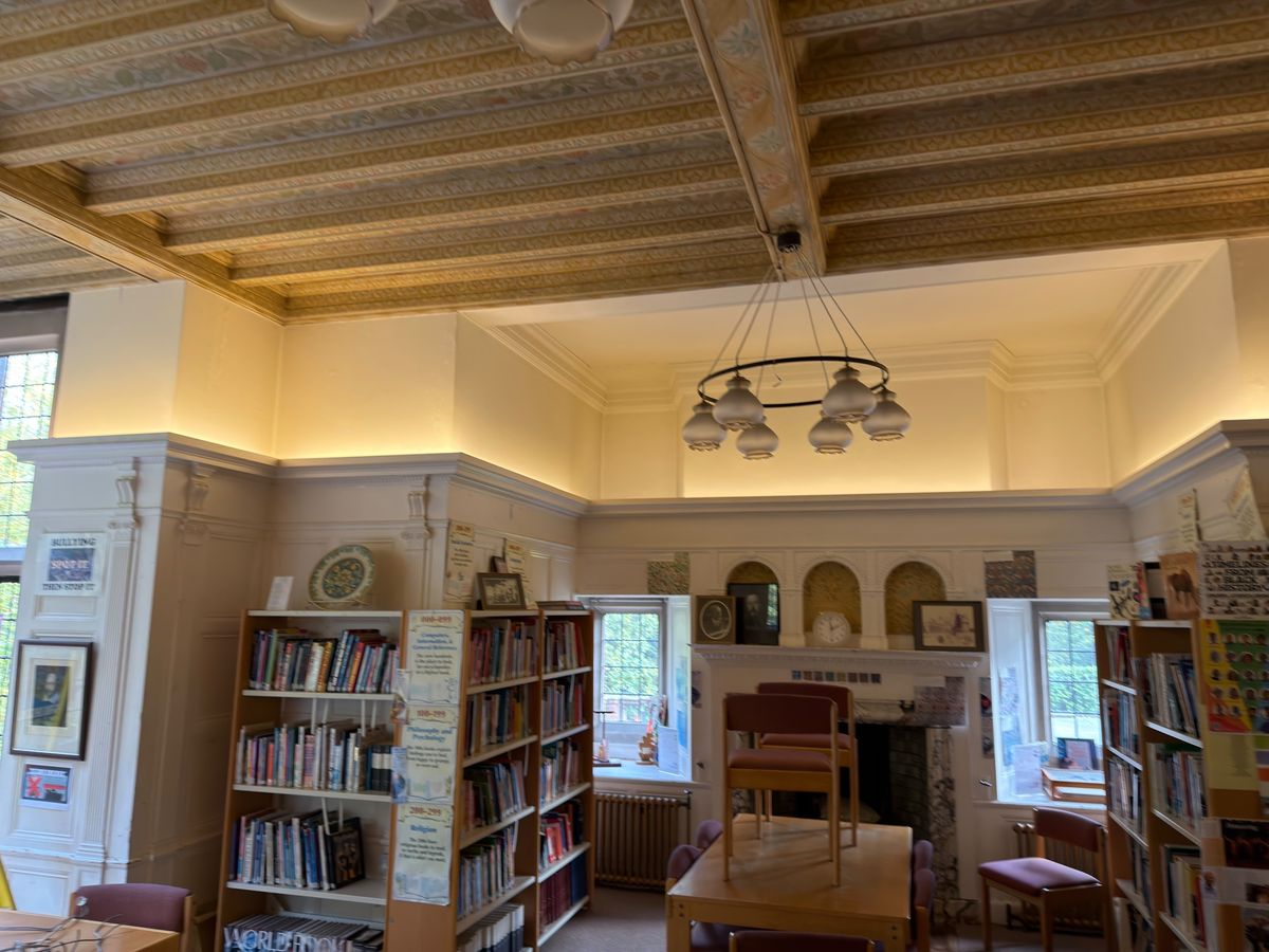 A soft, even glow over the bookshelves, fireplace and window bays