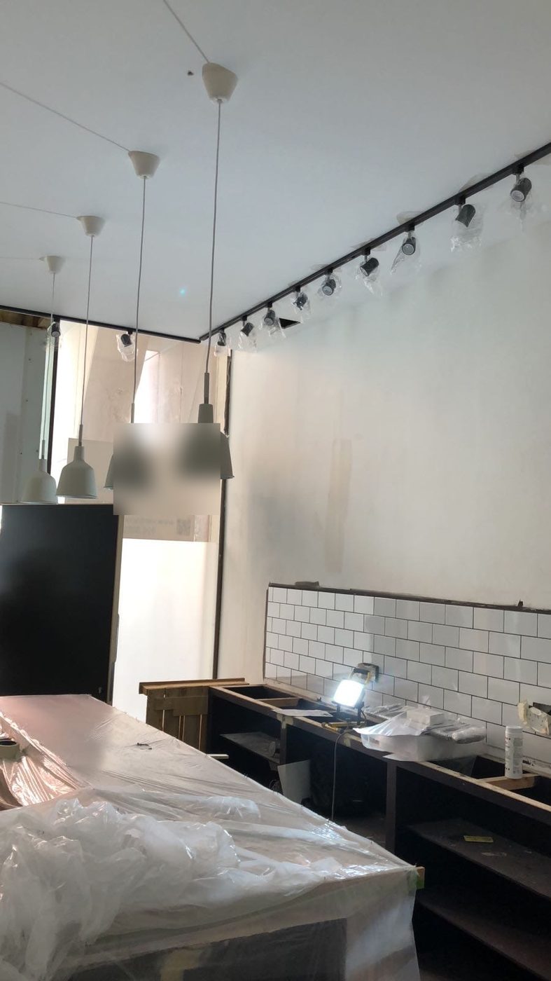 Track lighting along the wall above the tiled counter run