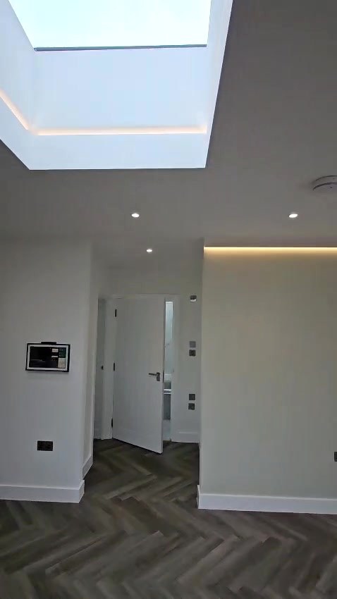 After: the roof lantern with LED cove lighting, downlights and a wall-mounted heating control panel