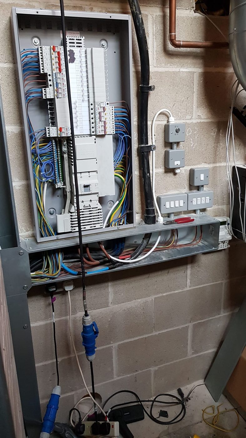 A three-phase board installed in a plant room, with steel trunking for the outgoing circuits