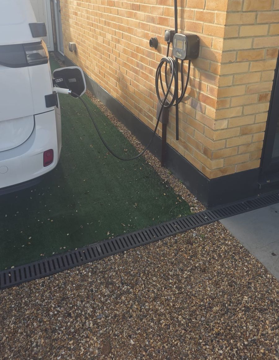 The charger in use, positioned so the cable reaches the car's charge port without stretching across the path