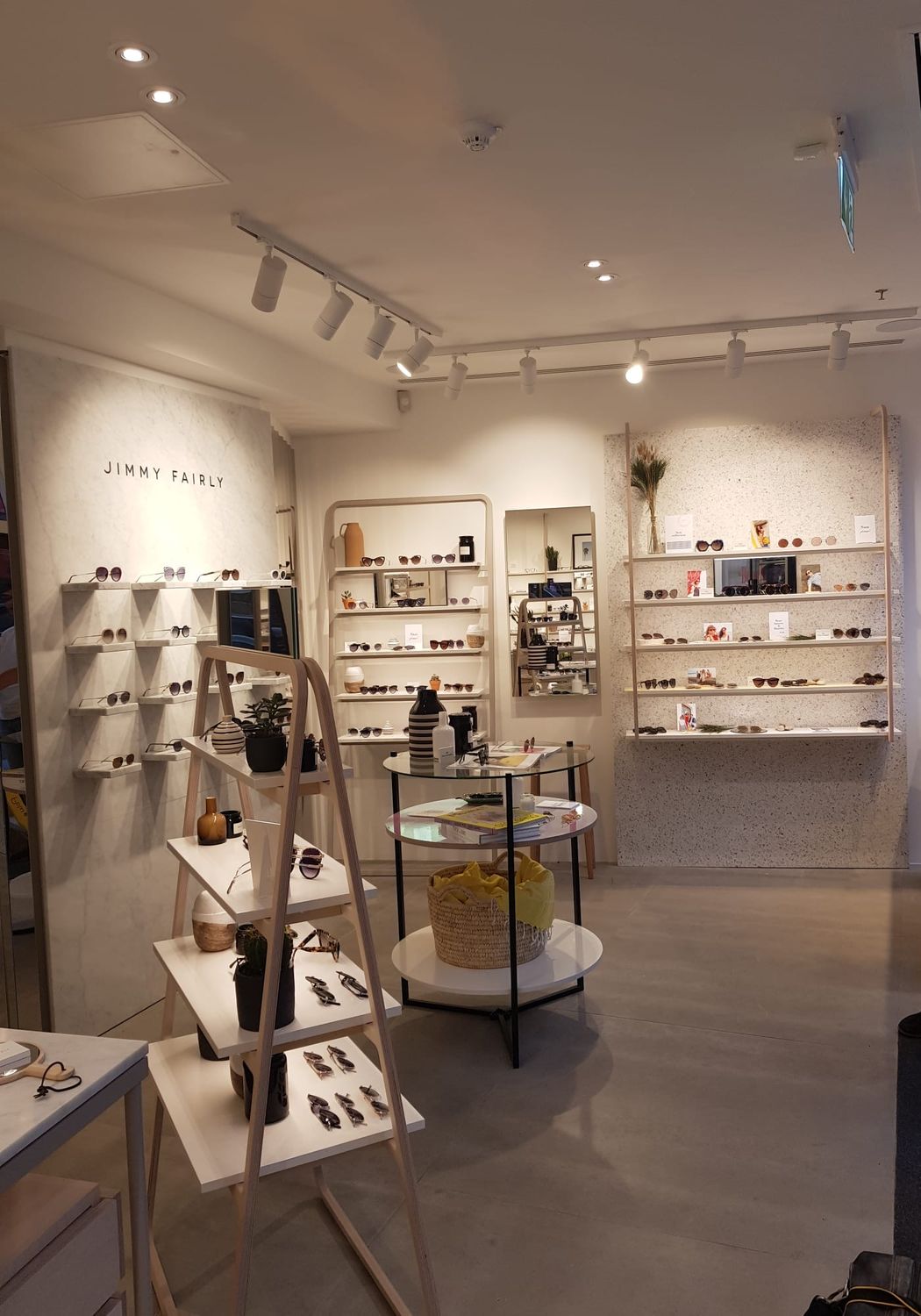 Inside Jimmy Fairly on Regent Street: track spotlights picking out the wall displays, with recessed downlights across the ceiling