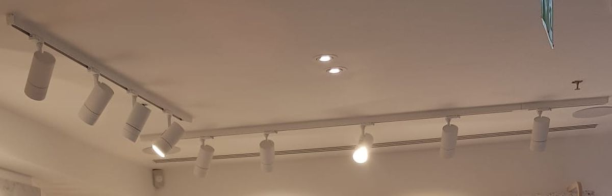 Runs of white track spotlights, each one aimed at a display wall