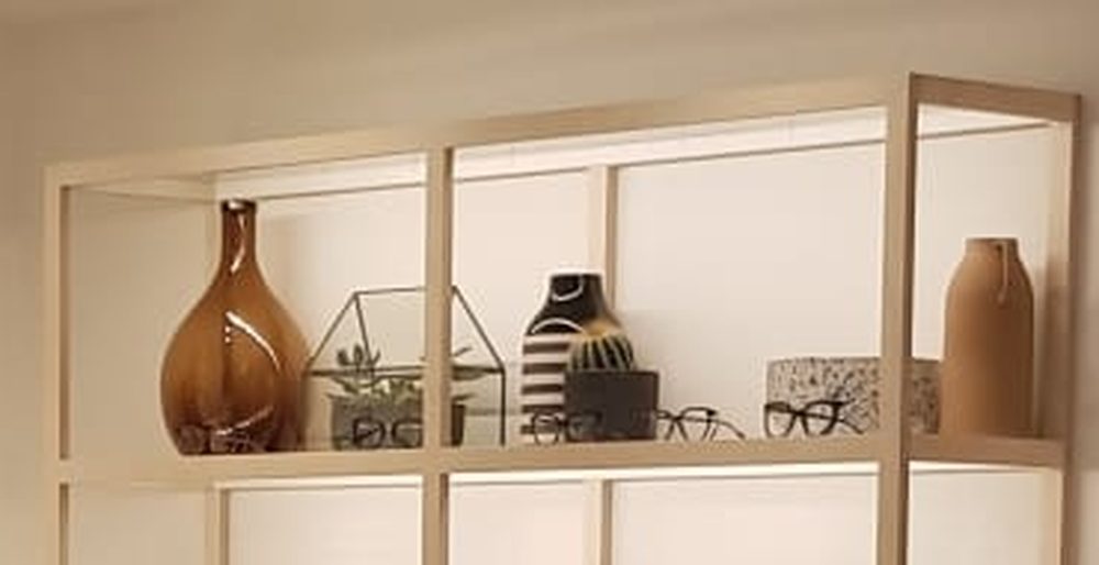 Shelving lit from within, so the frames stand out against a soft white glow