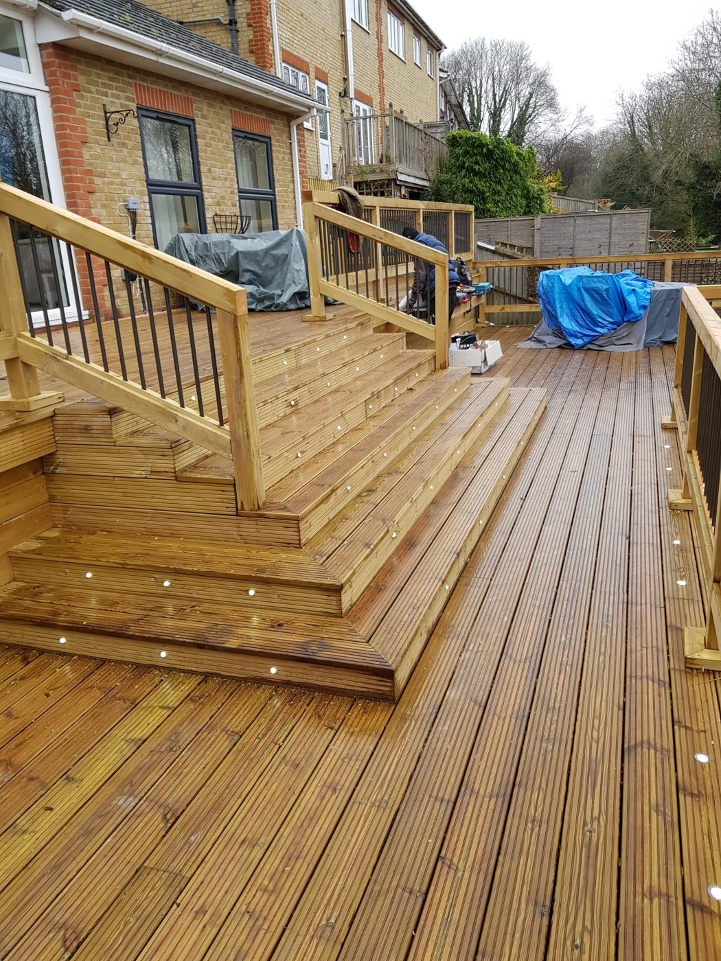 Raised decking with LED step and deck lights wired to an outdoor supply