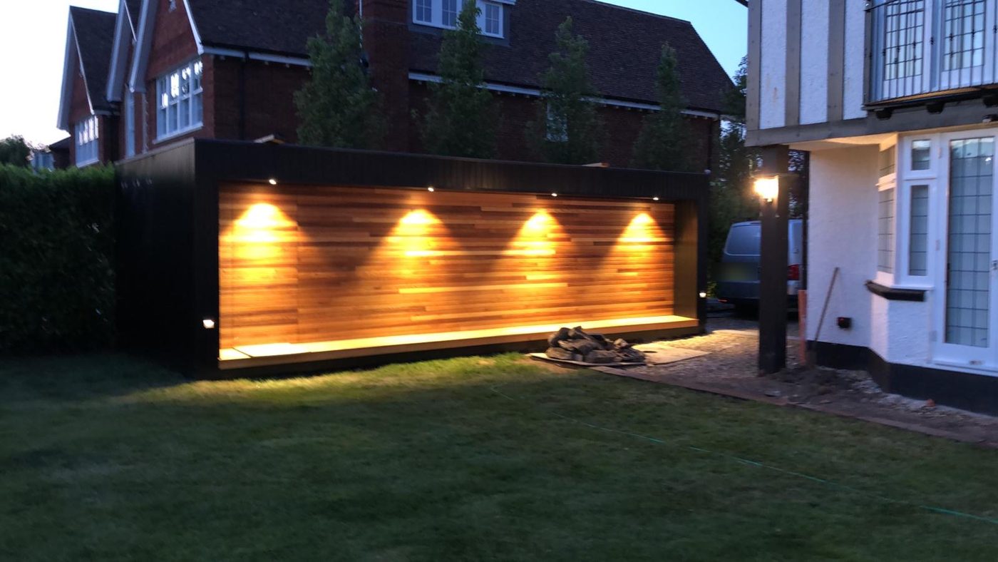 Garden room with a lit cedar feature wall, downlights and an LED plinth